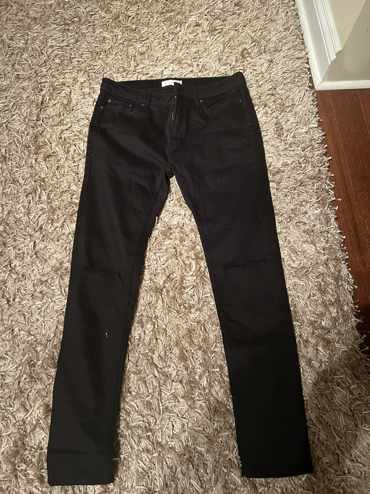 Black top man ripped knee jeans