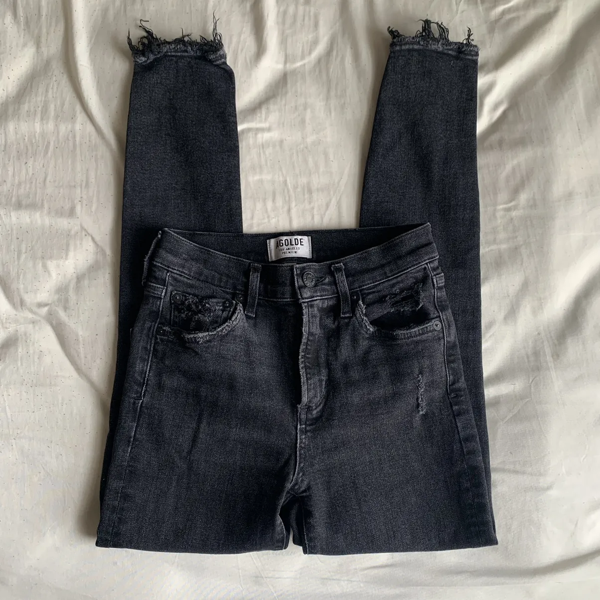 Agolde black high rise skinny jeans with distressed hems